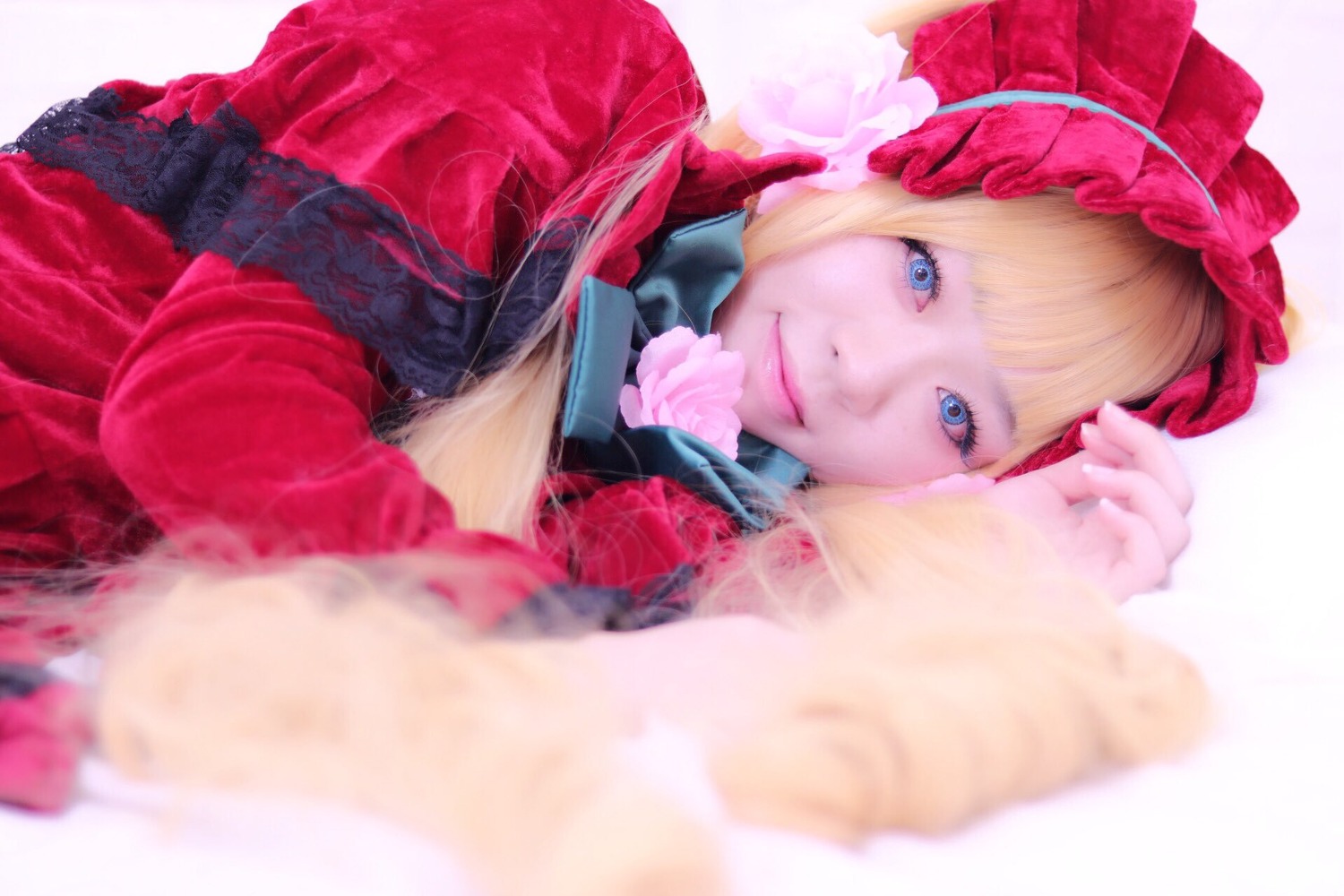 1girl bangs blonde_hair blue_eyes blurry blurry_background blurry_foreground bonnet depth_of_field dress flower looking_at_viewer photo pink_rose rose shinku smile solo