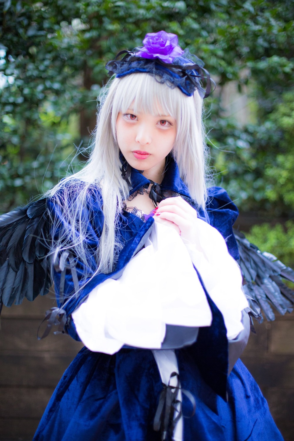 1girl bangs blue_dress blurry blurry_background capelet depth_of_field dress flower lips long_hair looking_at_viewer nail_polish solo suigintou