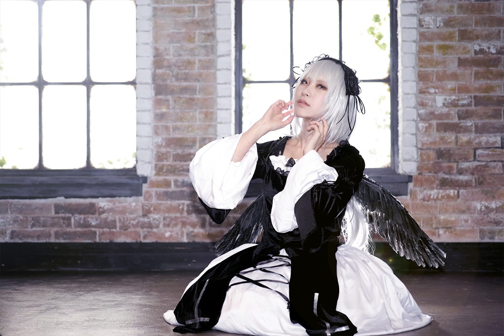 1girl architecture building closed_mouth dress feathered_wings feathers gothic_lolita hairband indoors lolita_fashion long_sleeves silver_hair sitting solo suigintou window wings