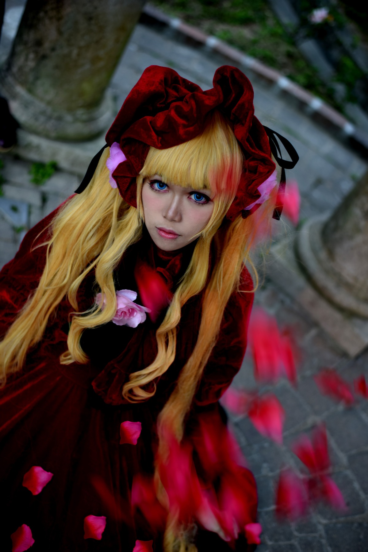 1girl bangs blonde_hair blue_eyes blurry blurry_background bonnet bow depth_of_field dress flower lips long_hair looking_at_viewer red_dress shinku solo twintails