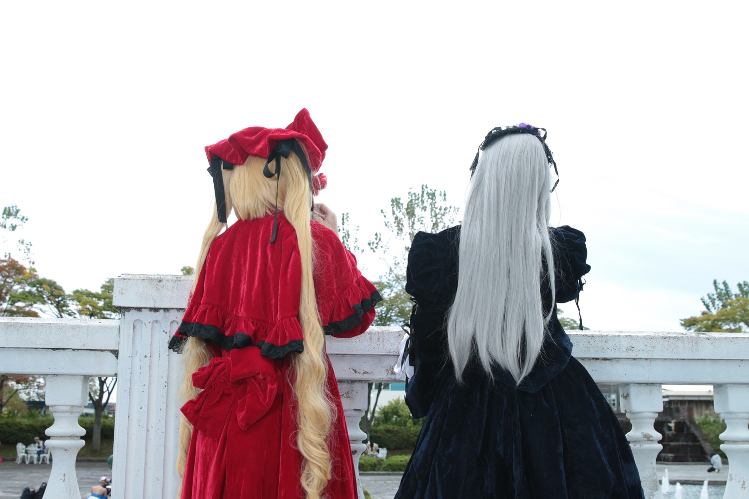 2girls black_dress blonde_hair building dress facing_away long_hair multiple_cosplay multiple_girls standing tagme tree