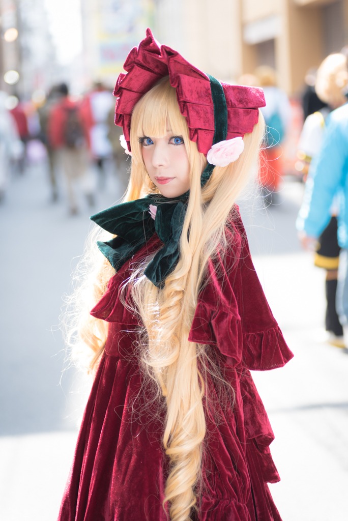 1girl 2girls blonde_hair blue_eyes blurry blurry_background blurry_foreground bonnet coat depth_of_field hat lips long_hair looking_at_viewer motion_blur multiple_girls photo shinku solo solo_focus standing