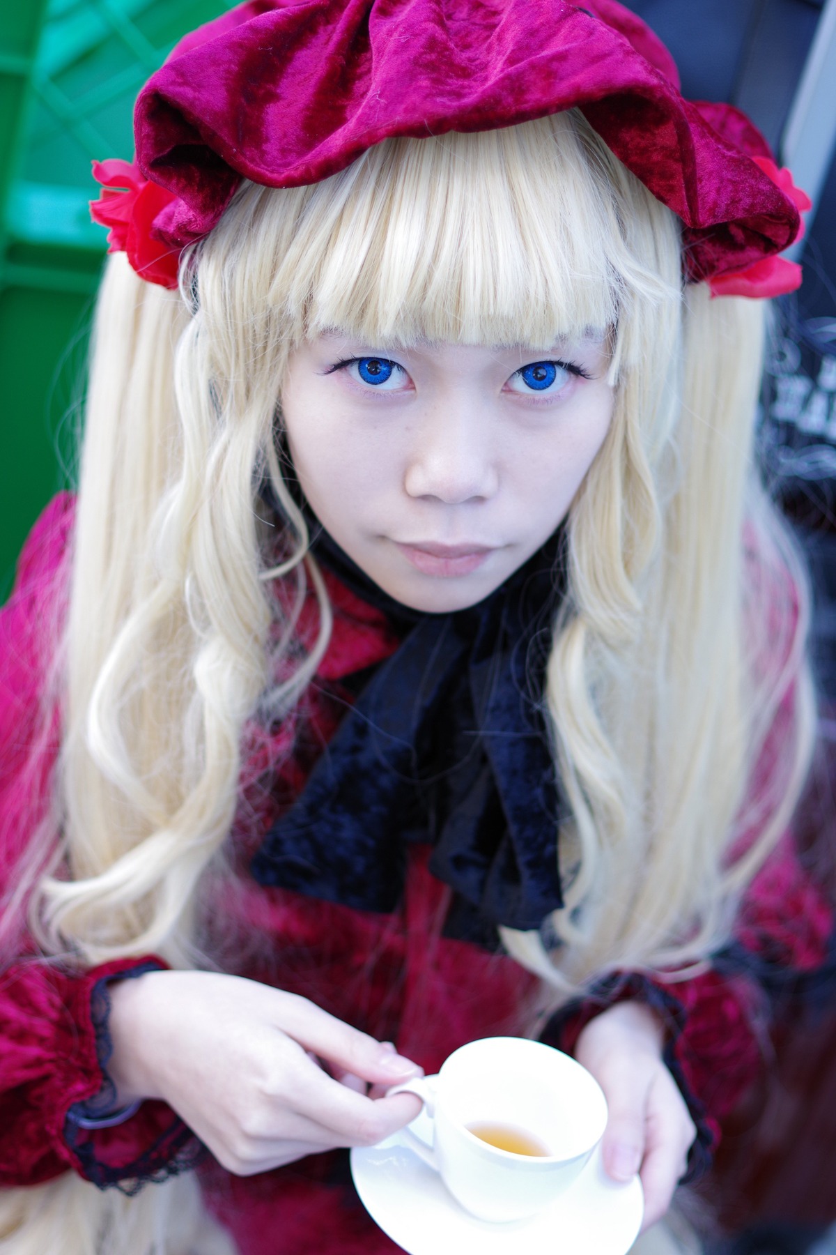 1girl bangs blonde_hair blue_eyes blunt_bangs blurry blurry_background bow closed_mouth cup depth_of_field eyelashes hat holding holding_cup lips long_hair looking_at_viewer saucer shinku solo tea teacup upper_body