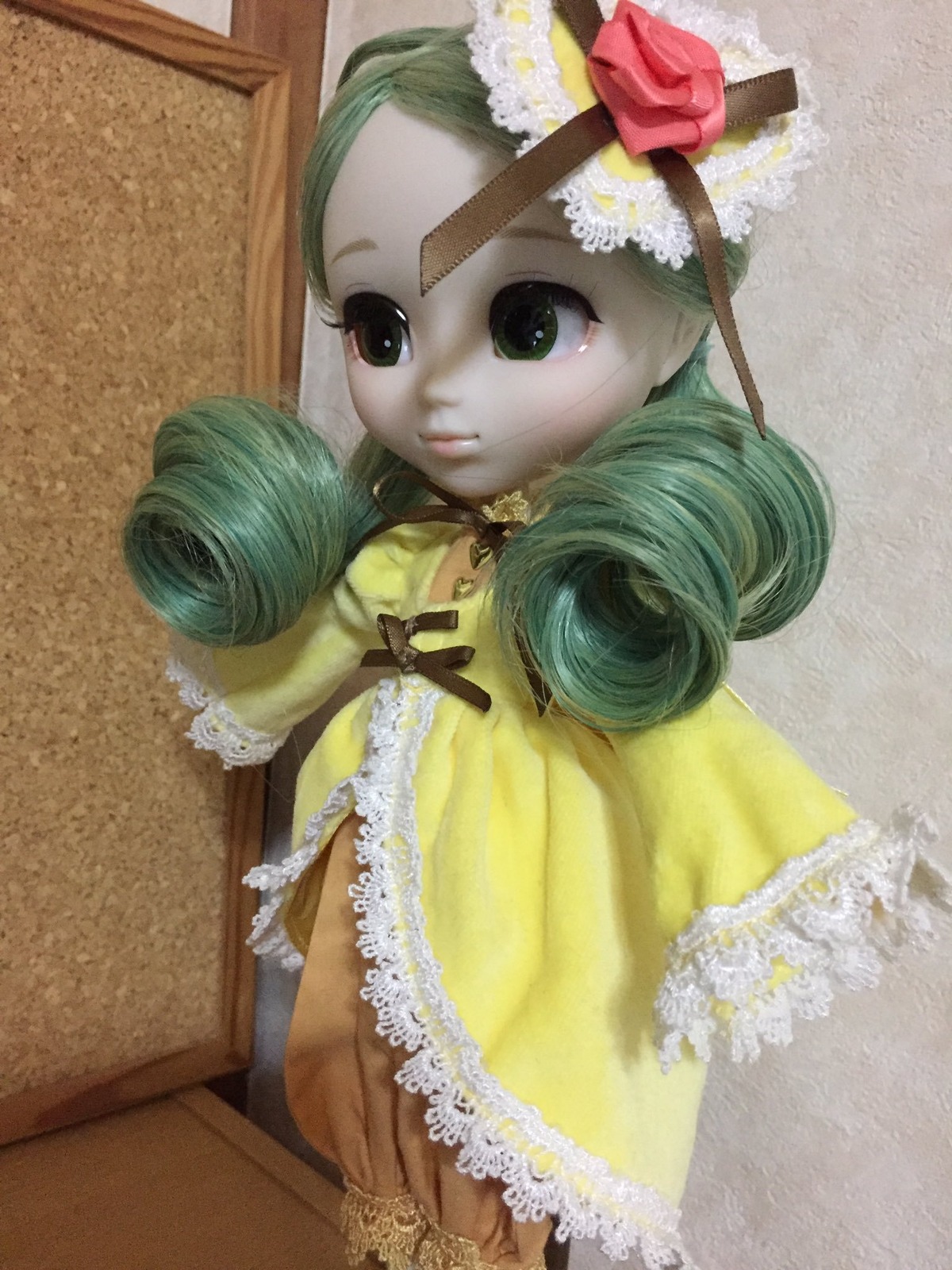 1girl closed_mouth doll dress drill_hair flower frills green_eyes green_hair hair_flower hair_ornament kanaria lace long_sleeves looking_at_viewer photo rose solo traditional_media twin_drills yellow_dress