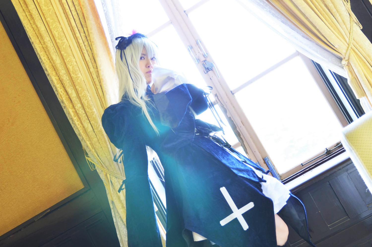 1girl blonde_hair blue_eyes curtains dress indoors long_hair ribbon solo standing suigintou window