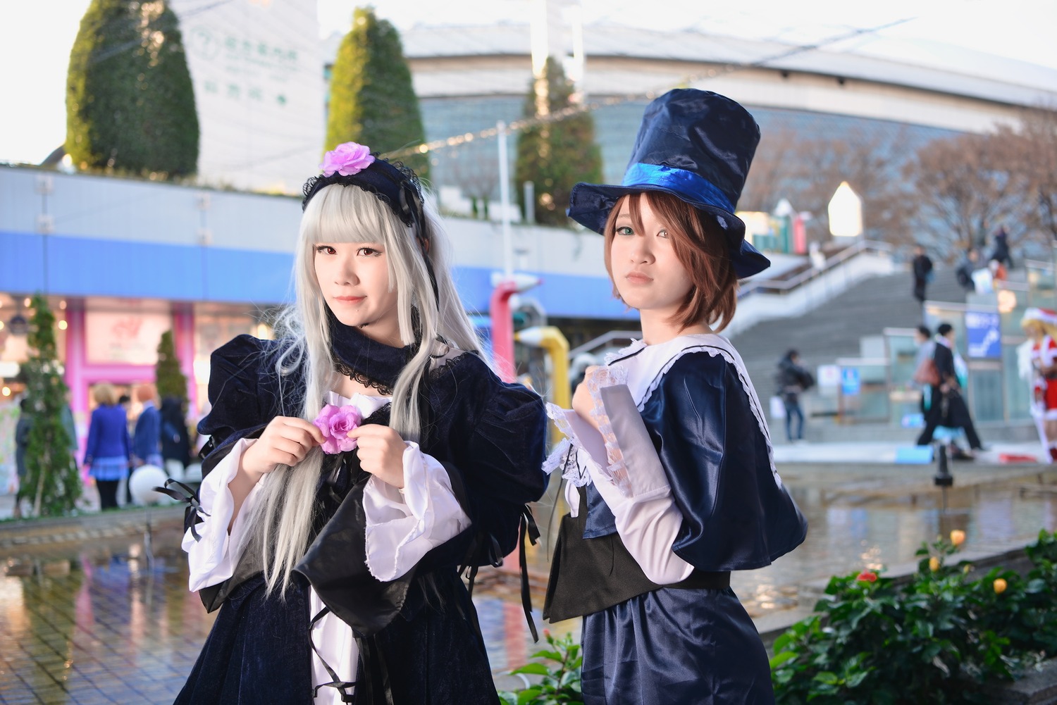 2girls blurry blurry_background brown_hair depth_of_field dress flower hat long_hair long_sleeves looking_at_viewer multiple_cosplay multiple_girls outdoors photo photo_background shopping street tagme