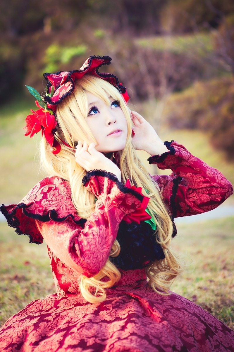 1girl blonde_hair blue_eyes blurry blurry_background bow capelet depth_of_field dress flower lips long_hair long_sleeves looking_at_viewer red_dress shinku solo