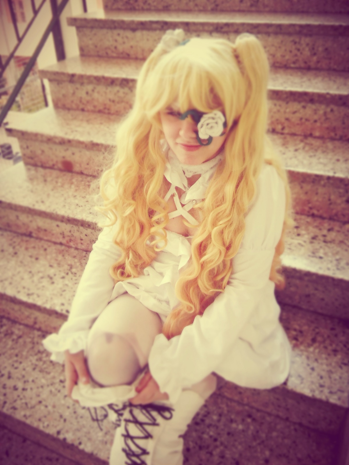 1girl blindfold blonde_hair blurry depth_of_field dress kirakishou long_hair sitting smile solo twintails