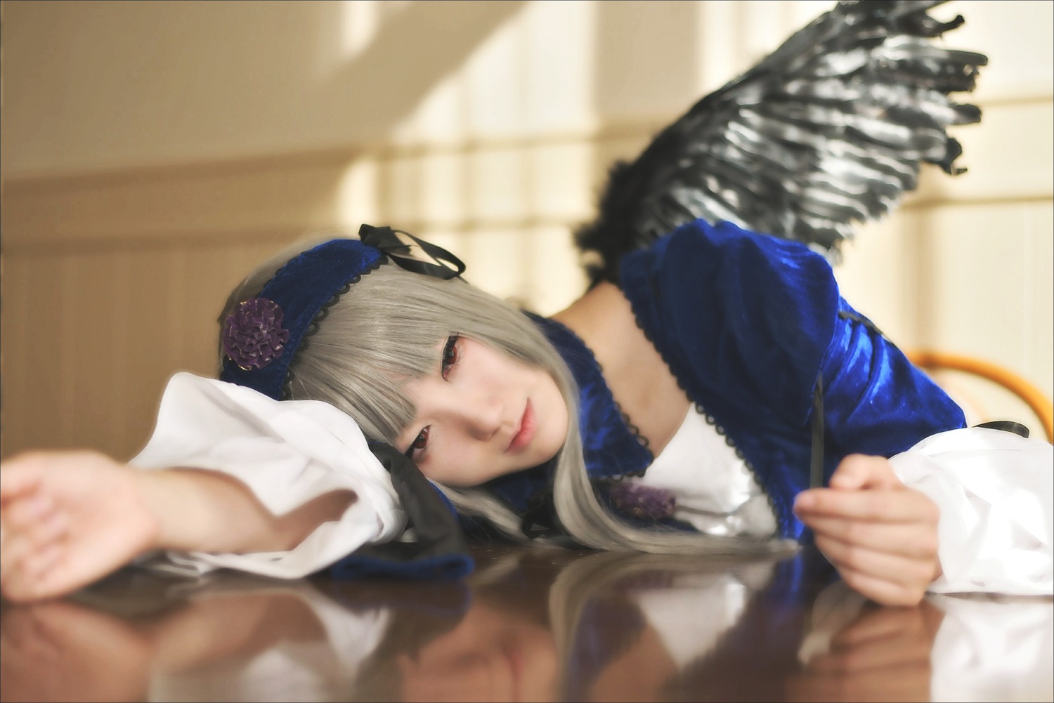 1girl black_wings blurry blurry_background blurry_foreground closed_mouth depth_of_field dress feathered_wings feathers hairband lace lips long_sleeves looking_at_viewer motion_blur out_of_frame photo smile solo solo_focus suigintou wings