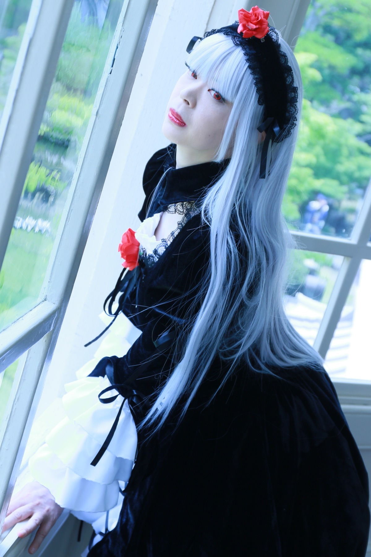 1girl black_dress blurry blurry_background depth_of_field dress flower frills gothic_lolita lips lolita_fashion long_hair long_sleeves pale_skin photo red_eyes rose solo suigintou very_long_hair white_hair