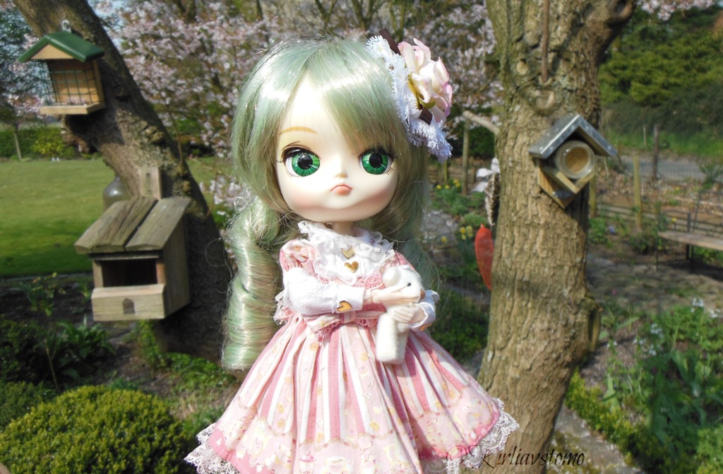 1girl doll dress flower grass green_eyes hair_flower hair_ornament kanaria outdoors pink_dress puffy_sleeves smile solo tree