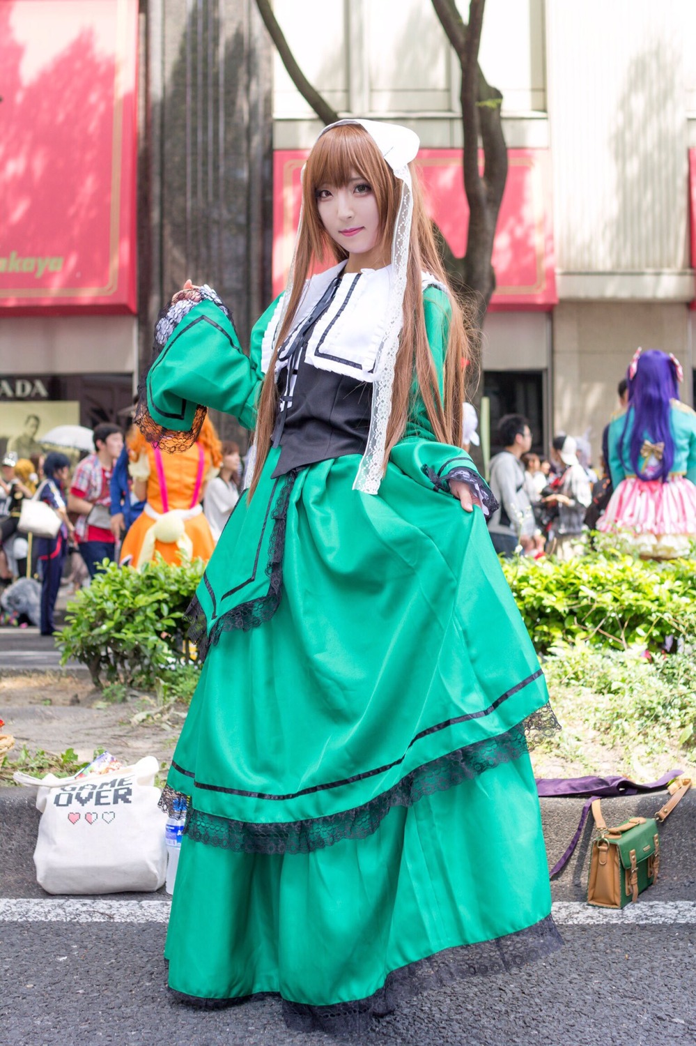 blurry blurry_background brown_hair day depth_of_field dress green_dress long_hair looking_at_viewer multiple_girls outdoors photo solo standing suiseiseki