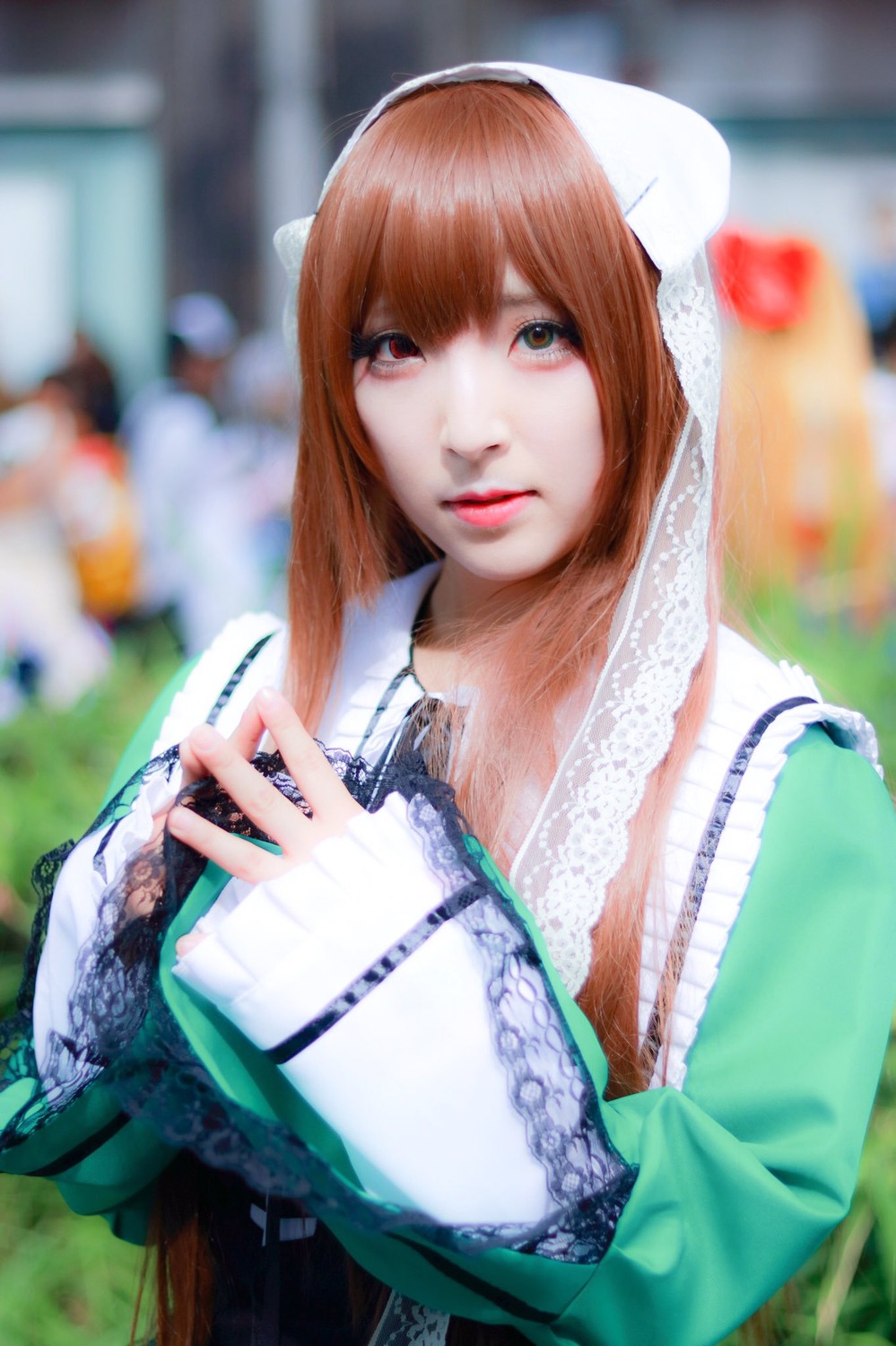 1girl 3d bangs blurry blurry_background blurry_foreground brown_hair depth_of_field green_dress holding lips long_hair looking_at_viewer photo solo suiseiseki upper_body