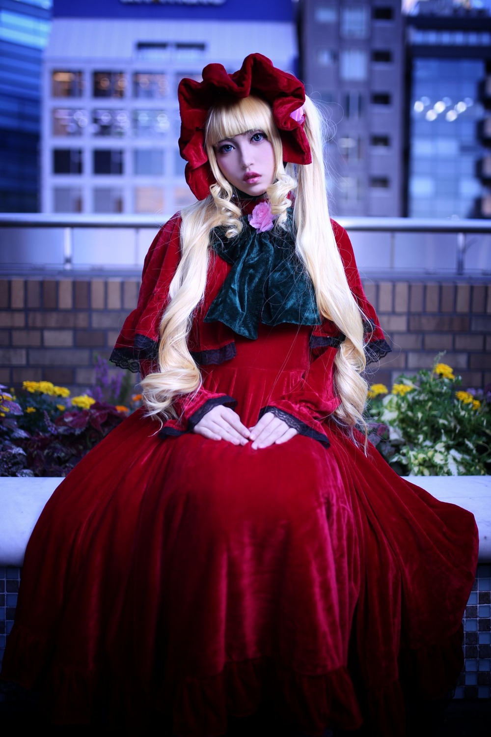 1girl blonde_hair blue_eyes blurry blurry_background bonnet depth_of_field dress flower hat long_sleeves looking_at_viewer outdoors red_dress shinku solo standing