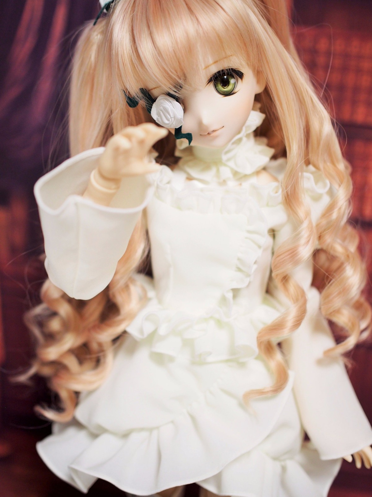 1girl bangs blonde_hair blurry blurry_foreground depth_of_field doll dress eyepatch flower green_eyes kirakishou lace lips lolita_fashion long_hair long_sleeves looking_at_viewer rose sitting solo white_dress