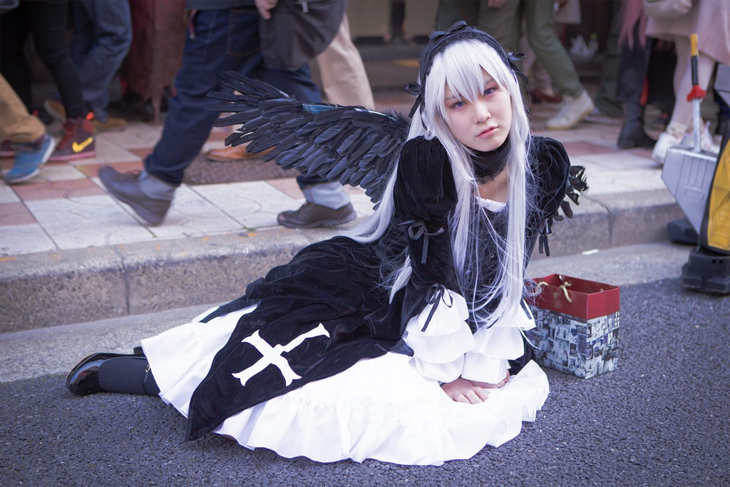 1girl black_dress black_wings blurry depth_of_field dress feathered_wings feathers frills gothic_lolita hairband lolita_fashion long_hair long_sleeves ribbon silver_hair sitting solo suigintou wings