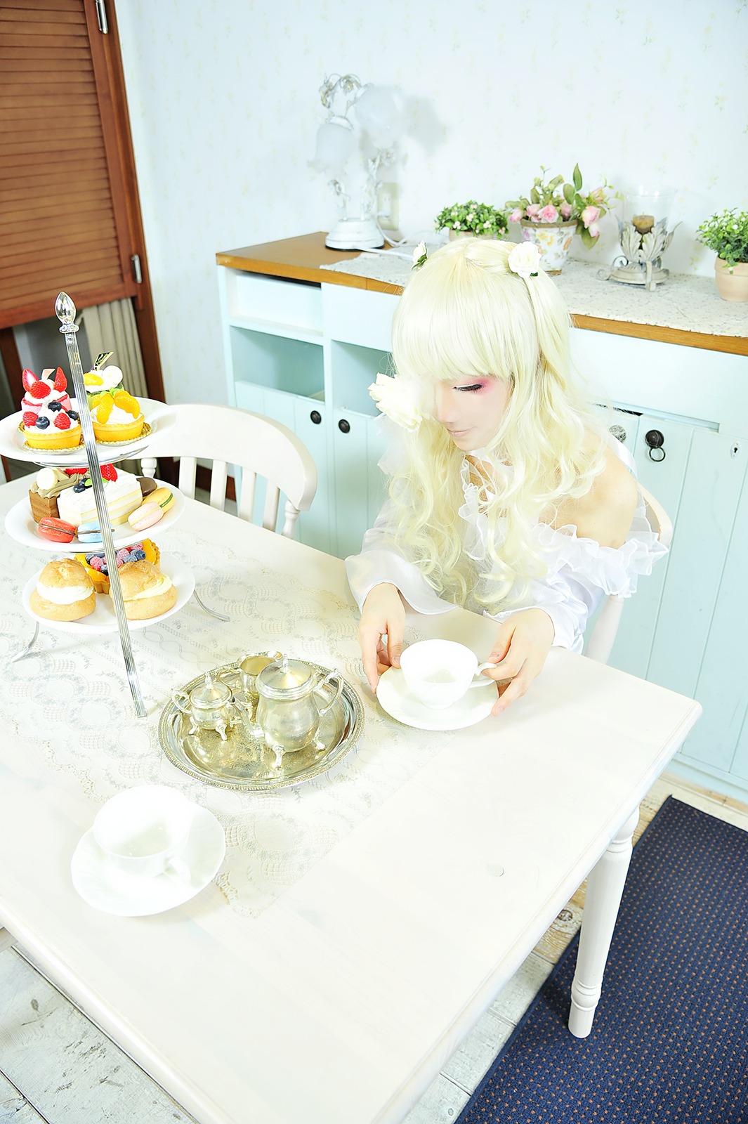 1girl blonde_hair closed_eyes cup dress flower food indoors kirakishou long_hair sitting solo spoon teacup window