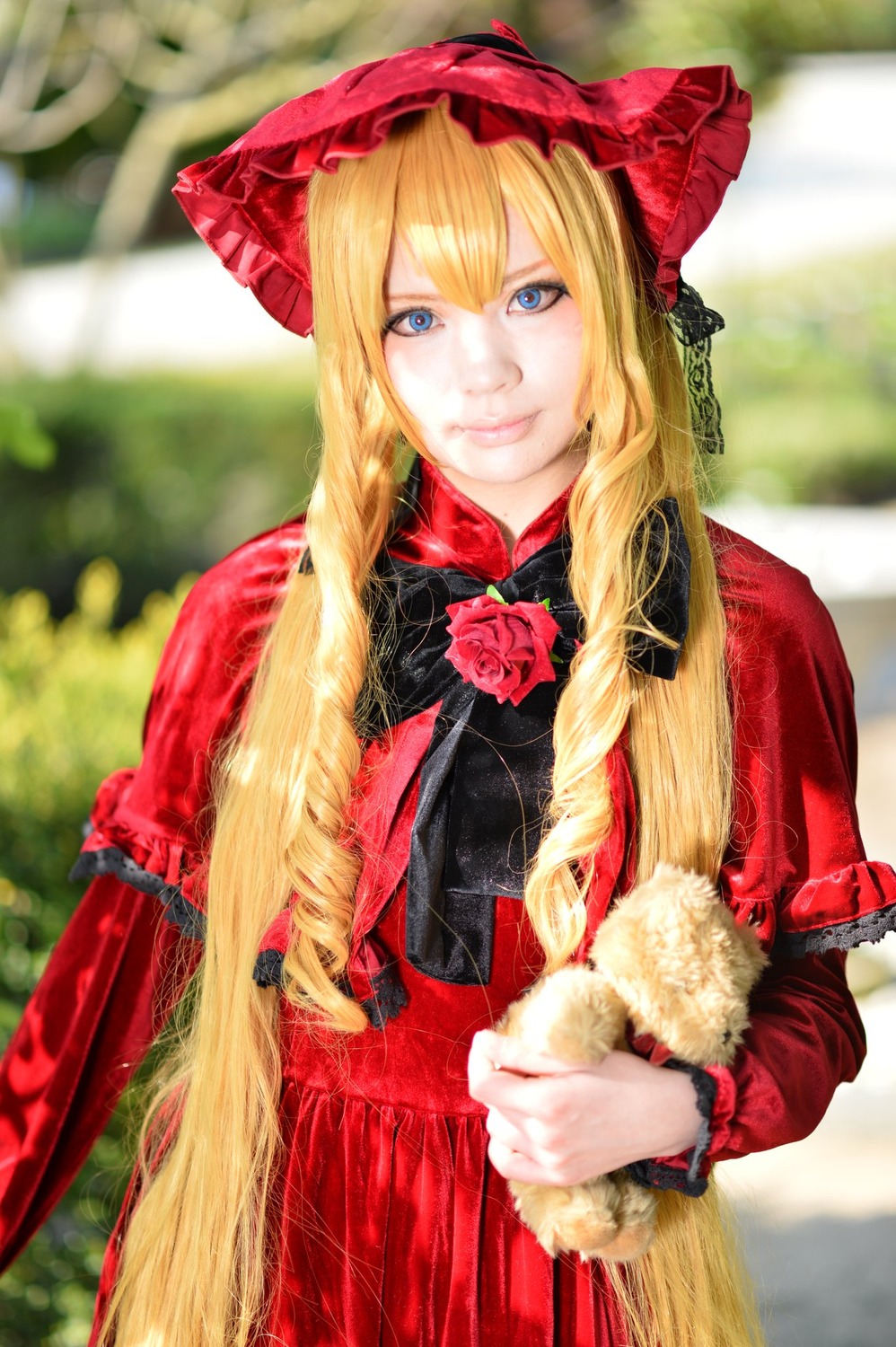 1girl blonde_hair blue_eyes blurry blurry_background bonnet depth_of_field flower hat lips long_hair long_sleeves looking_at_viewer photo realistic red_dress rose shinku smile solo