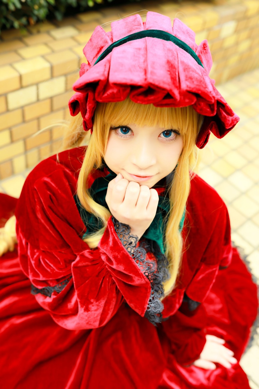 1girl bangs blonde_hair blue_eyes blurry blurry_background bonnet bow depth_of_field dress flower hat long_hair long_sleeves looking_at_viewer red_dress rose shinku sitting smile solo