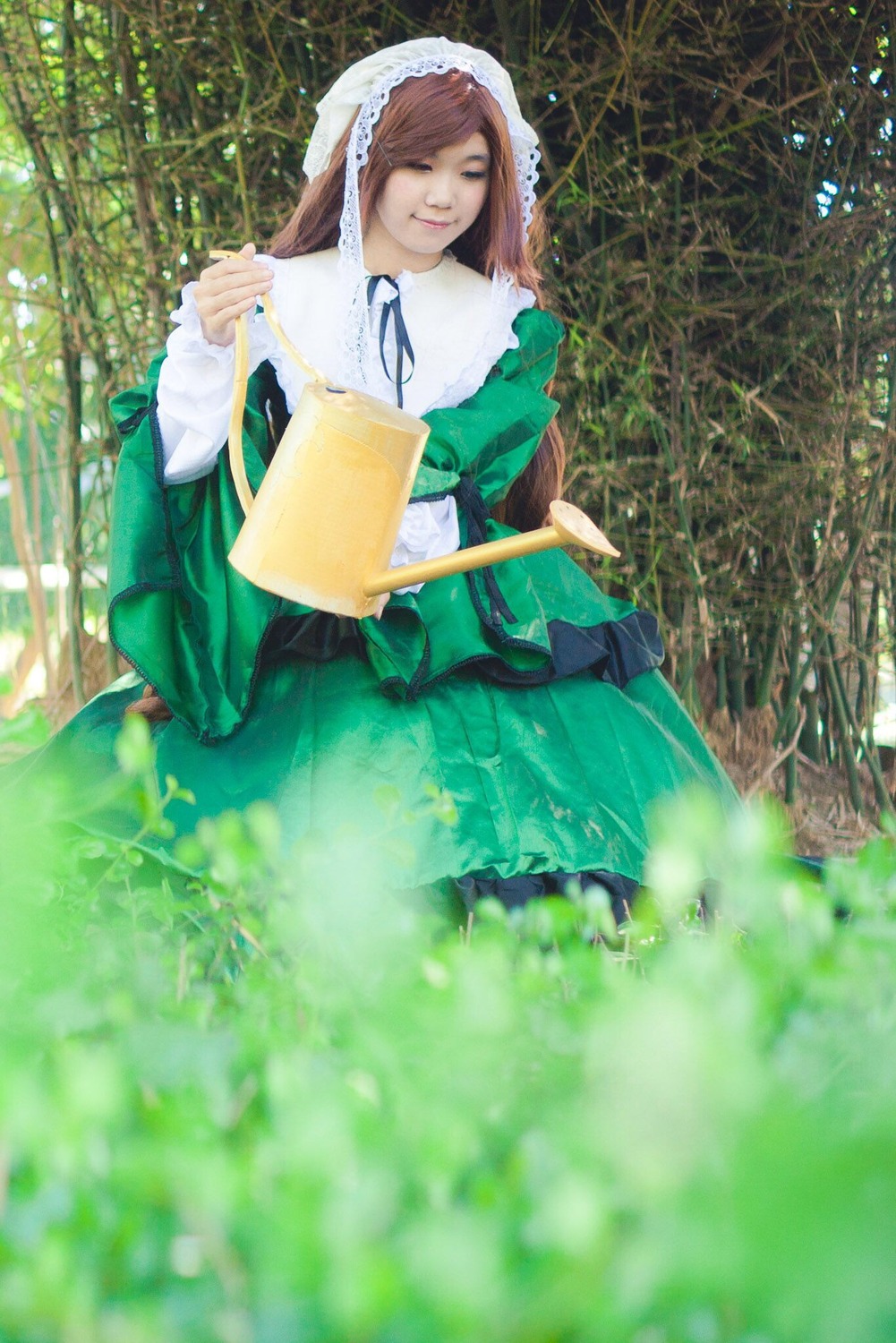 1girl brown_hair closed_eyes dress flower grass green_dress long_hair long_sleeves outdoors ribbon sitting smile solo suiseiseki watering_can