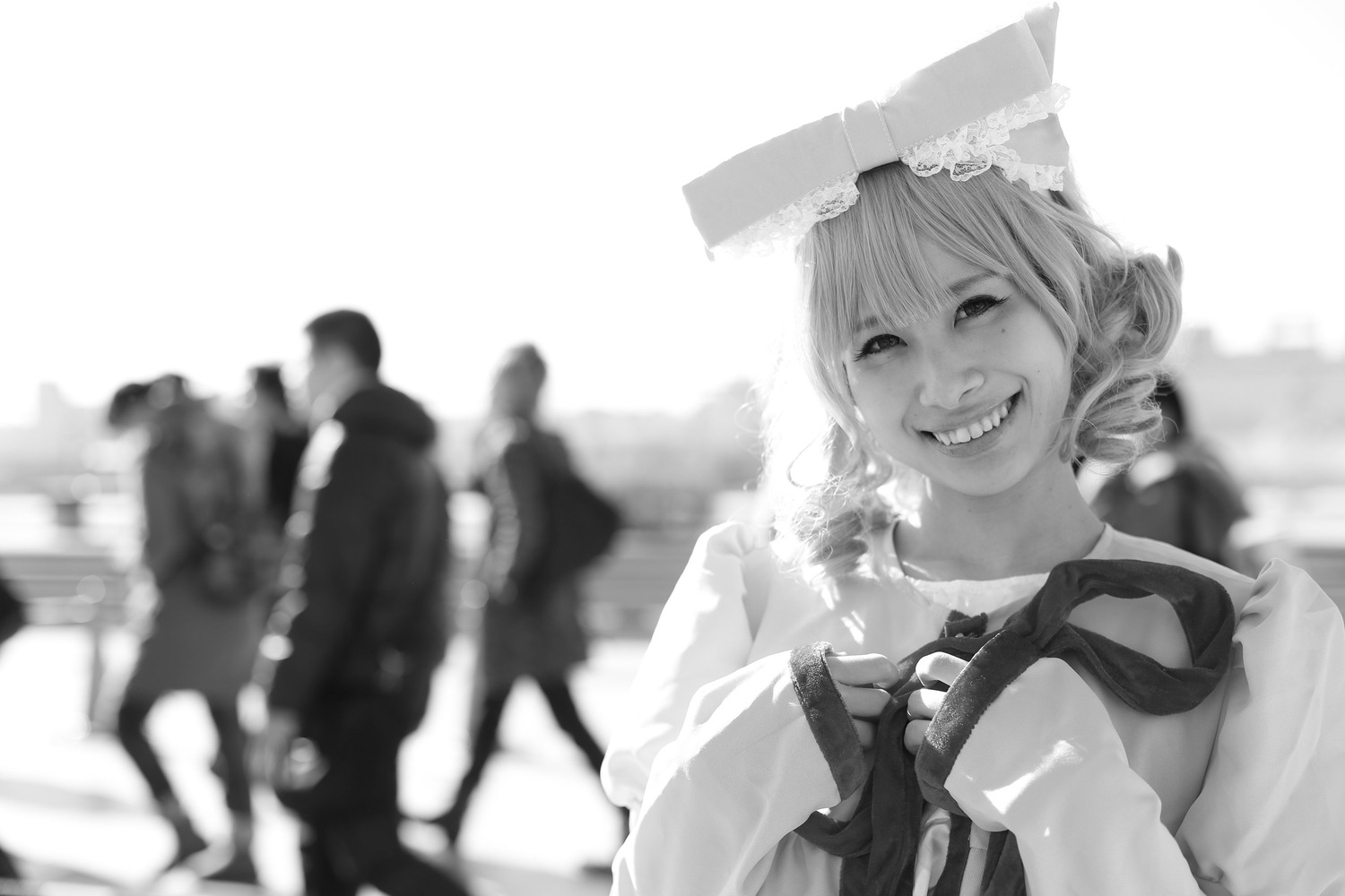 1girl blurry blurry_background blurry_foreground depth_of_field greyscale hat hinaichigo monochrome sharp_teeth smile solo teeth