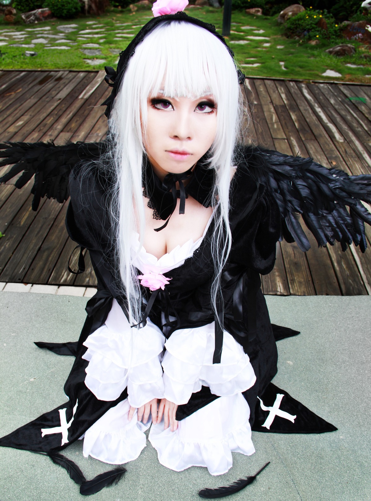 1girl auto_tagged bench black_wings breasts cleavage dress feathered_wings feathers from_above gothic_lolita hairband lips long_hair looking_at_viewer purple_eyes sitting solo suigintou v_arms wings