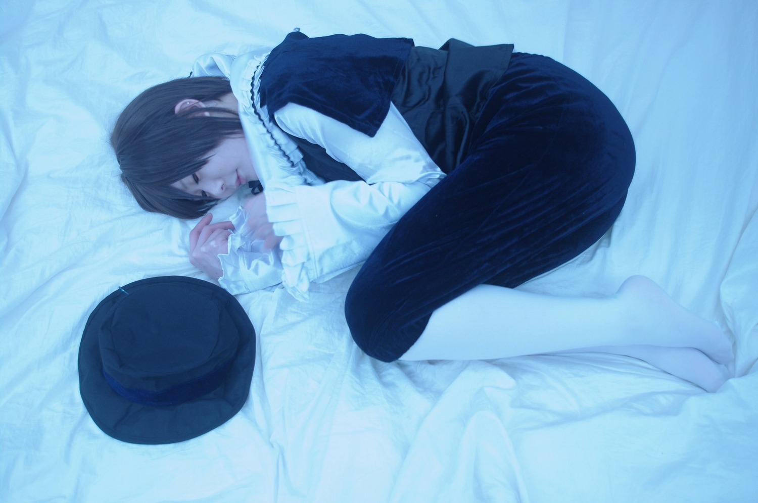 1girl barefoot black_hair blue_background blue_theme closed_eyes fetal_position hat hat_removed long_sleeves on_side short_hair skirt solo