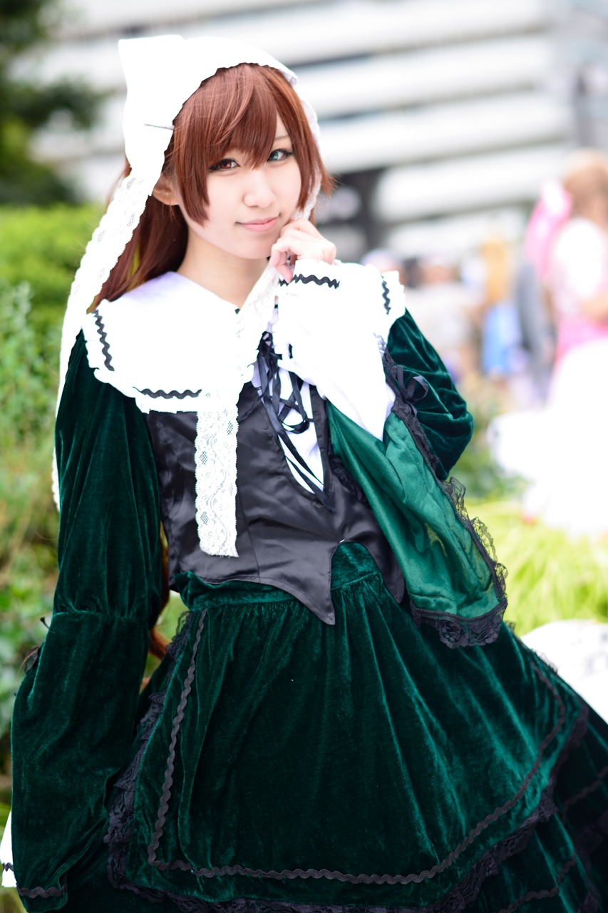 1girl blurry blurry_background blurry_foreground brown_hair depth_of_field dress green_dress lips long_hair long_sleeves looking_at_viewer photo smile solo suiseiseki