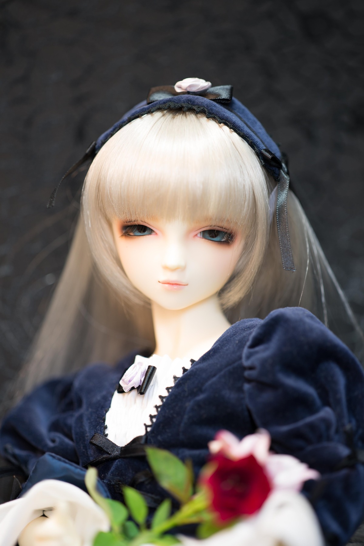 1girl bangs blonde_hair blue_eyes blurry blurry_foreground depth_of_field doll flower hairband lips long_hair photo ribbon rose solo suigintou upper_body