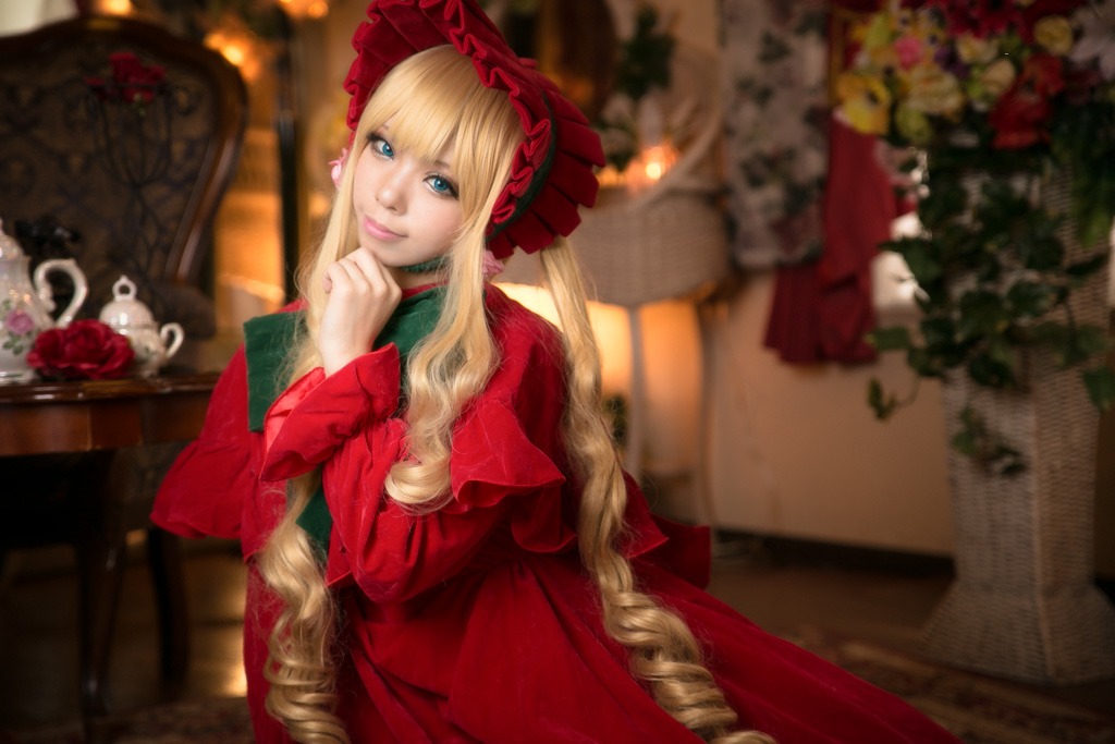 1girl blonde_hair blue_eyes blurry blurry_background blurry_foreground bonnet depth_of_field dress drill_hair flower lips long_hair looking_at_viewer photo realistic red_dress red_flower red_rose rose shinku smile solo vase very_long_hair