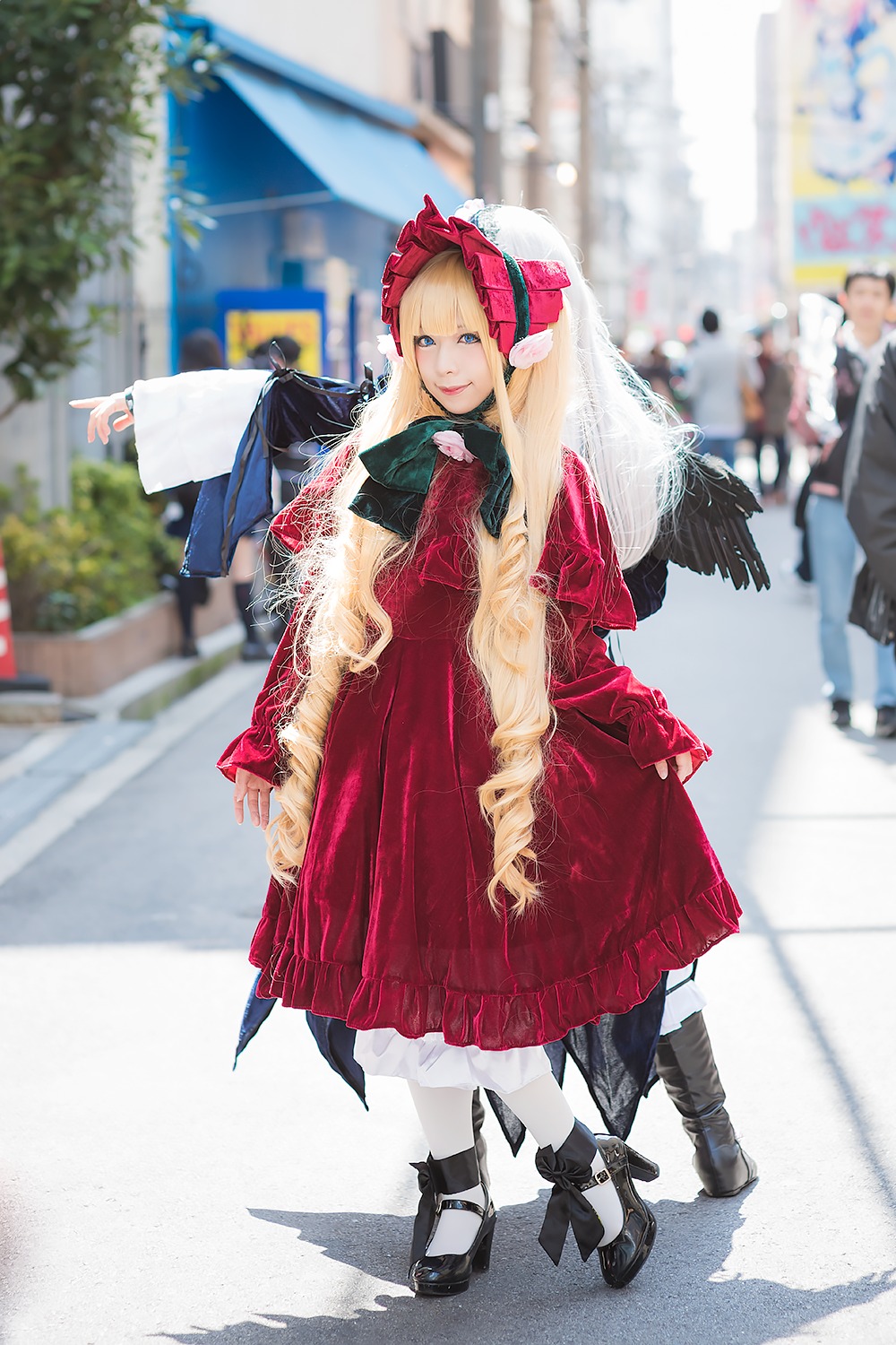 1girl black_footwear black_hair blonde_hair blurry blurry_background blurry_foreground boots depth_of_field dress frills long_hair long_sleeves looking_at_viewer outdoors photo red_dress shadow shinku smile solo standing white_legwear wings